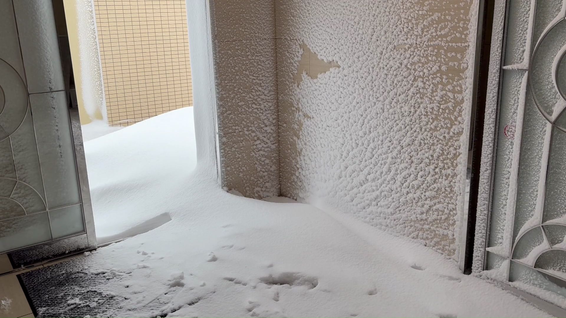 吹き溜まりで自動ドアが閉まらず玄関が凍り付いてしまう