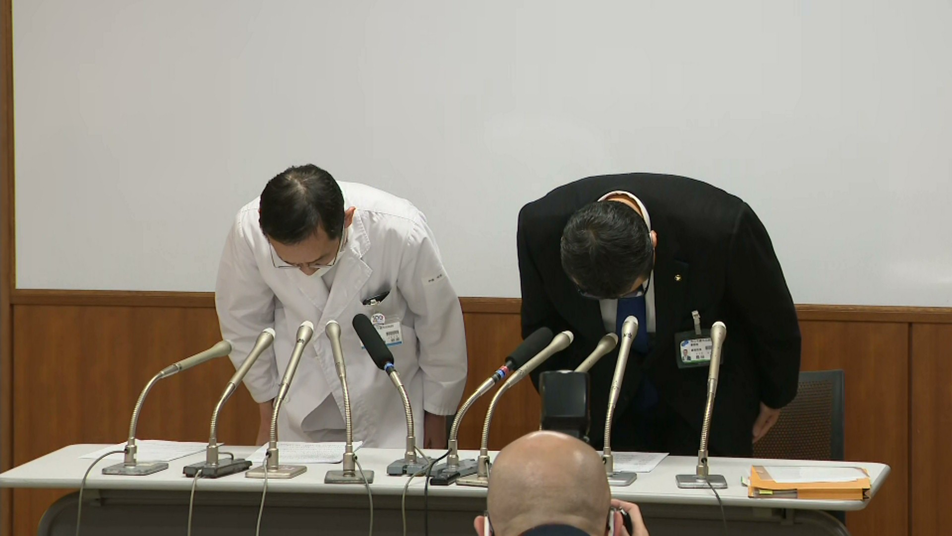 会見で陳謝する院長(左)と事務局長(右)